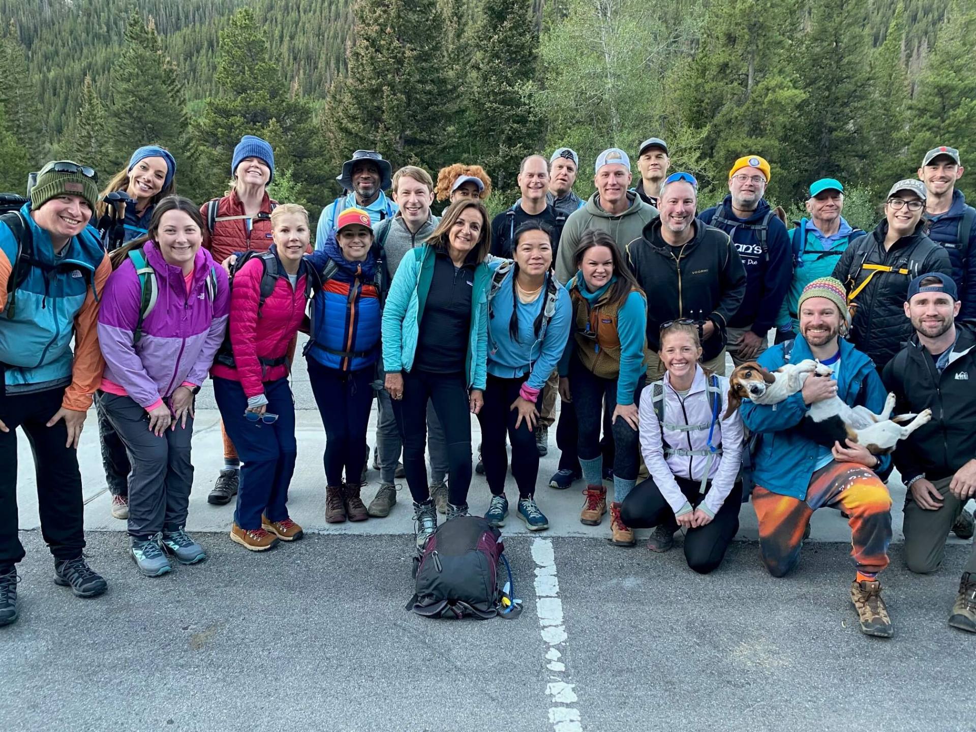 Friends gather for a photo in front of a breathtaking mountain, capturing a moment of joy and camaraderie.