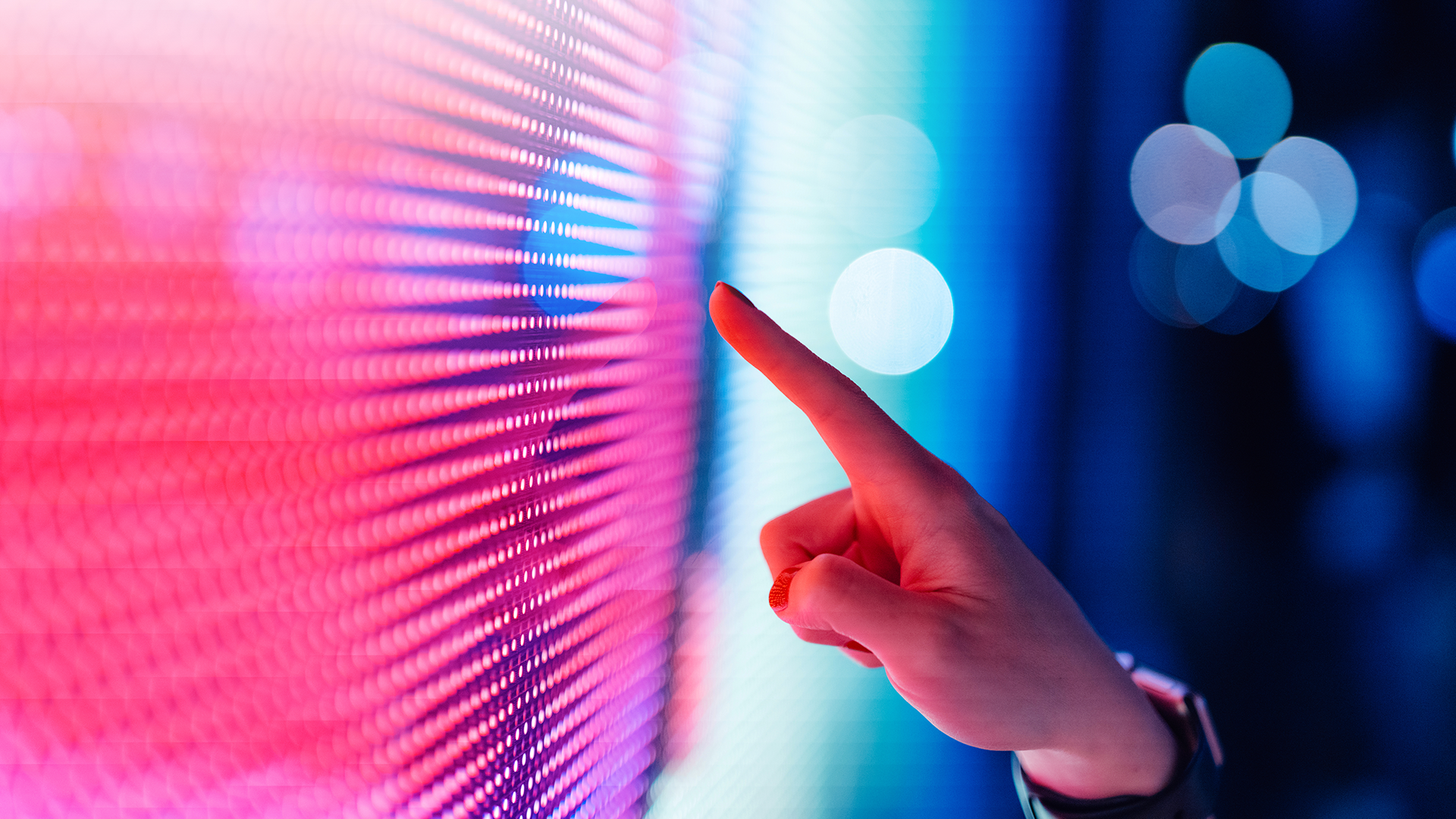 A person interacting with a large, colorful touchscreen, directing attention to the vivid content displayed.