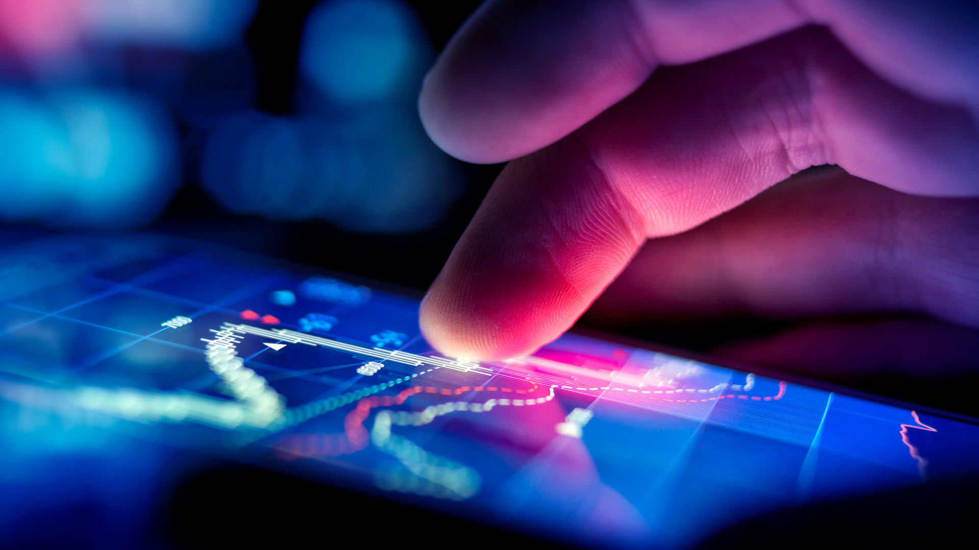 An individual touching a digital screen that features a graphical representation of data trends.