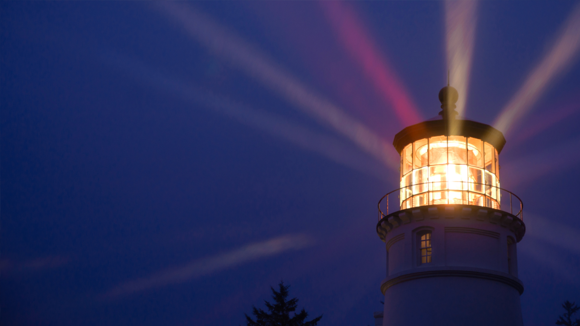 A lighthouse with powerful light beams shining through, serving as a beacon for navigation in the dark.