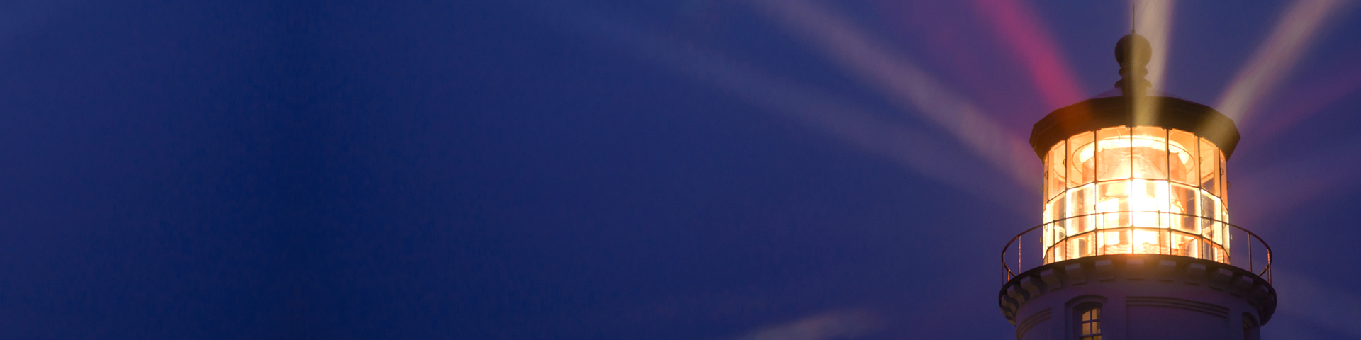 A lighthouse with powerful light beams shining through, serving as a beacon for navigation in the dark.