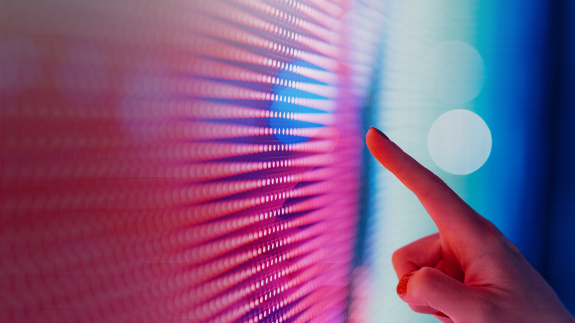A close-up of a finger making contact with a bright, colorful touchscreen, illustrating user engagement with the device.