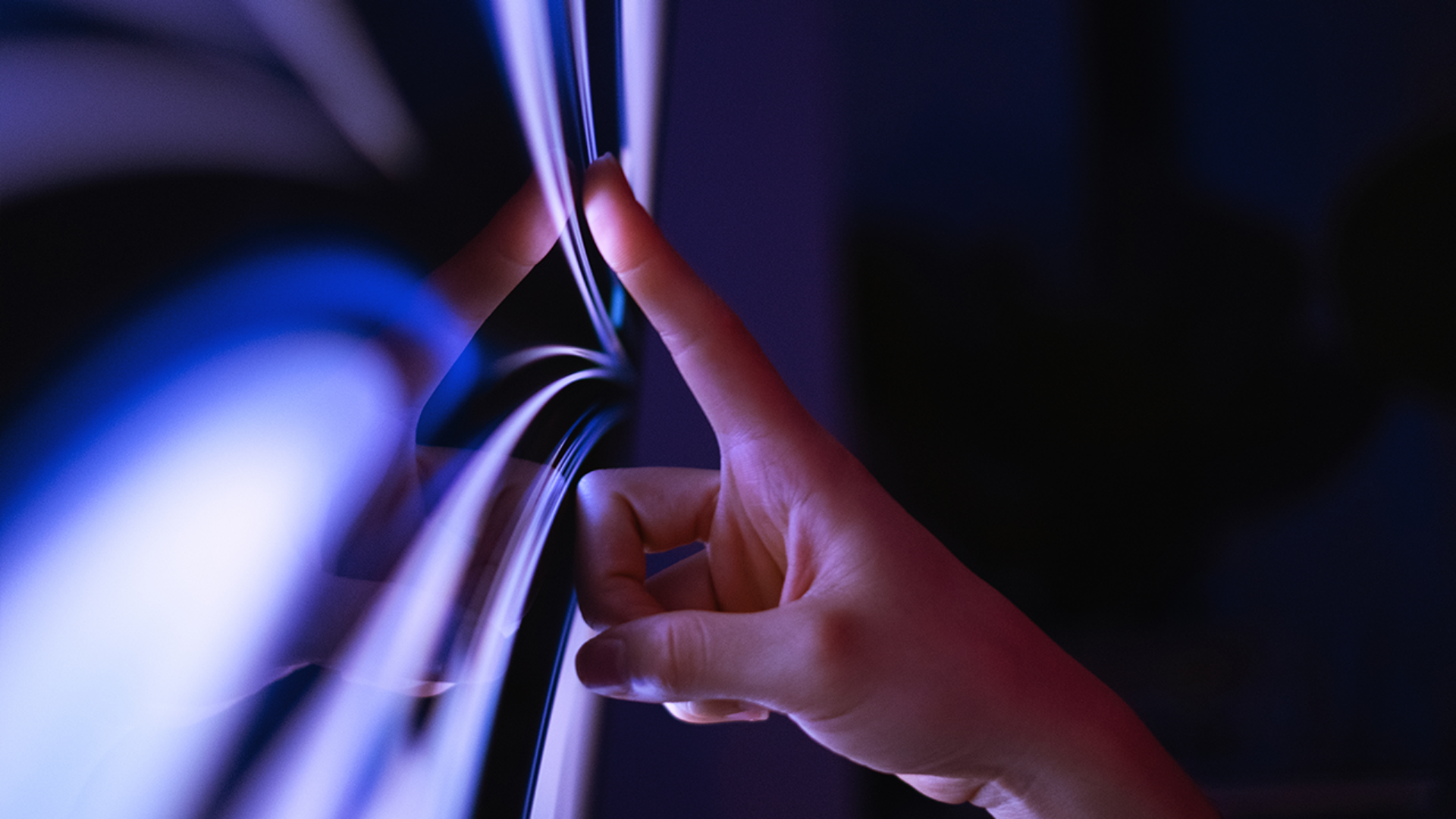 A close-up of the interaction between persons hand and a large touch screen display.