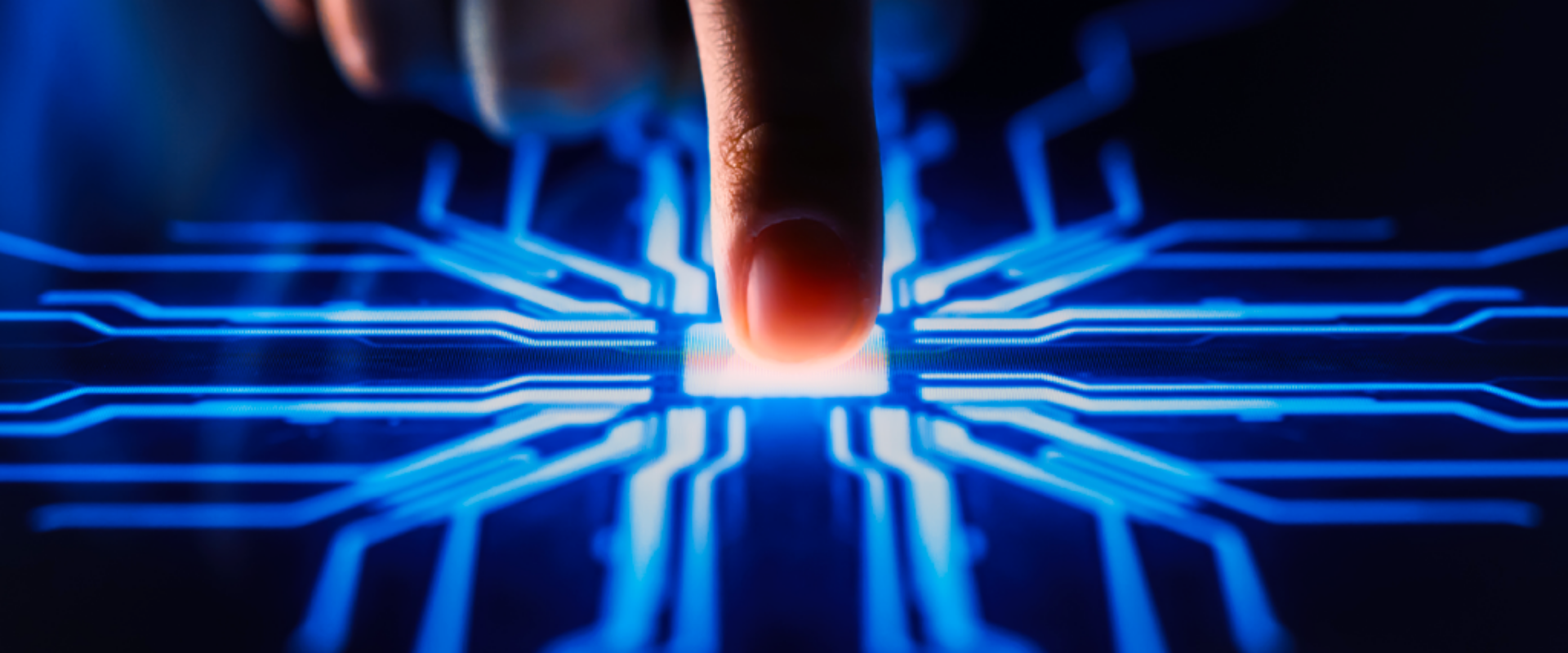A close-up of a hand activating a button on a circuit board, showcasing the connection between human and technology.