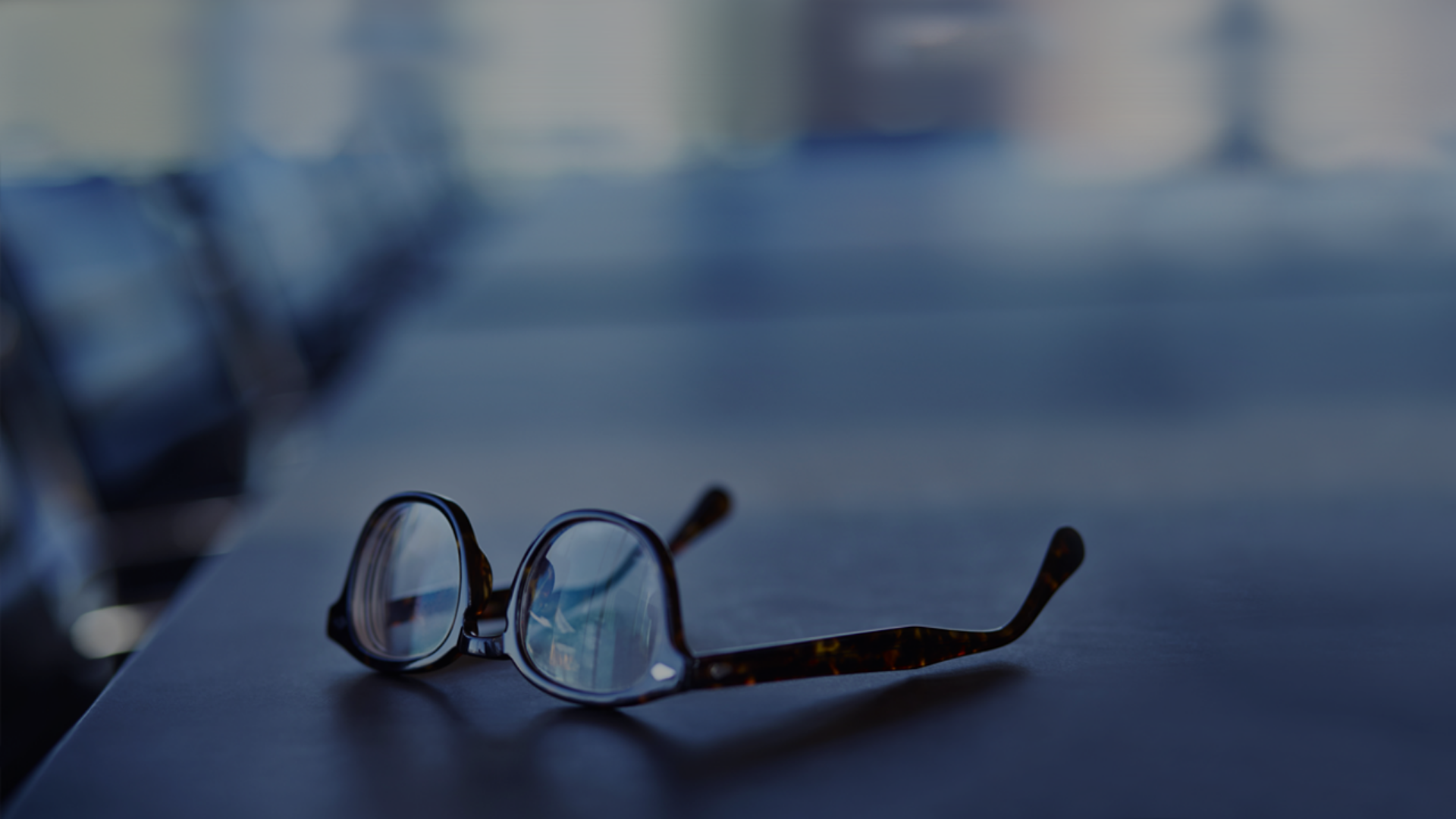 A stylish pair of glasses placed on a table, highlighting their frame and lens clarity.