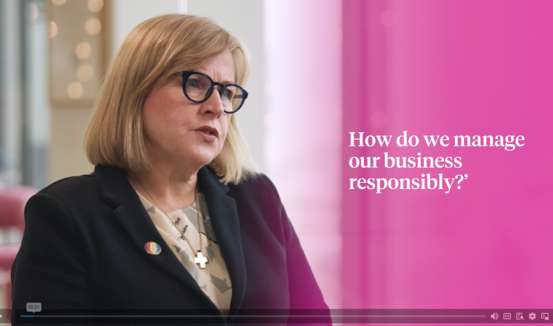 A professional woman wearing glasses and a suit jacket speaks on sustainability, highlighting the importance of eco-friendly practices.