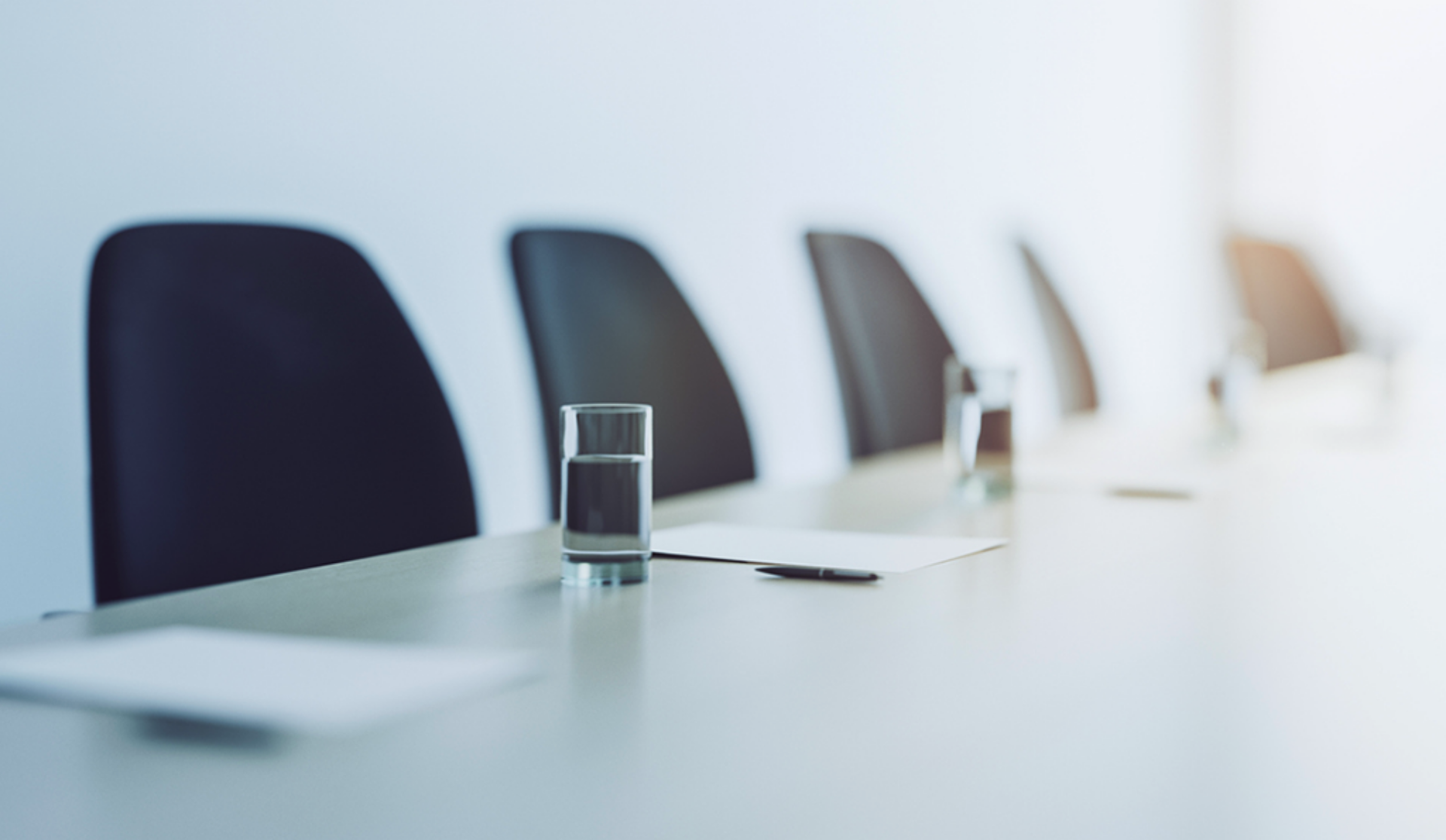 A well-arranged conference table with chairs and glasses of water, set for discussions and collaboration.