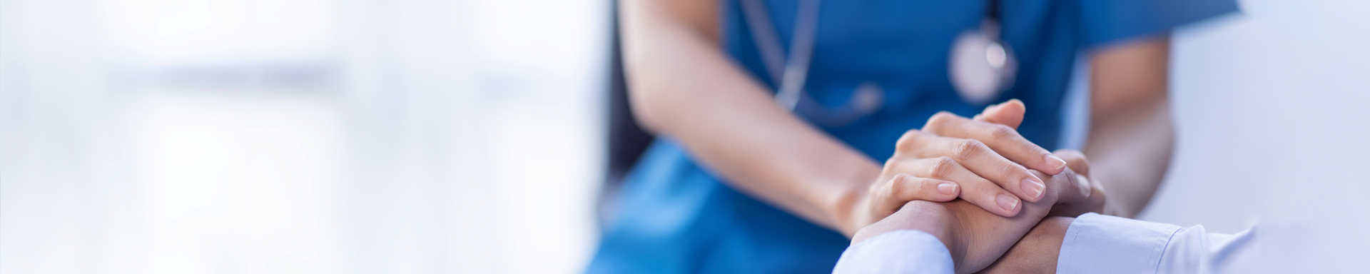 A nurse is seen holding a patient's hand, conveying warmth and reassurance in a healthcare setting.