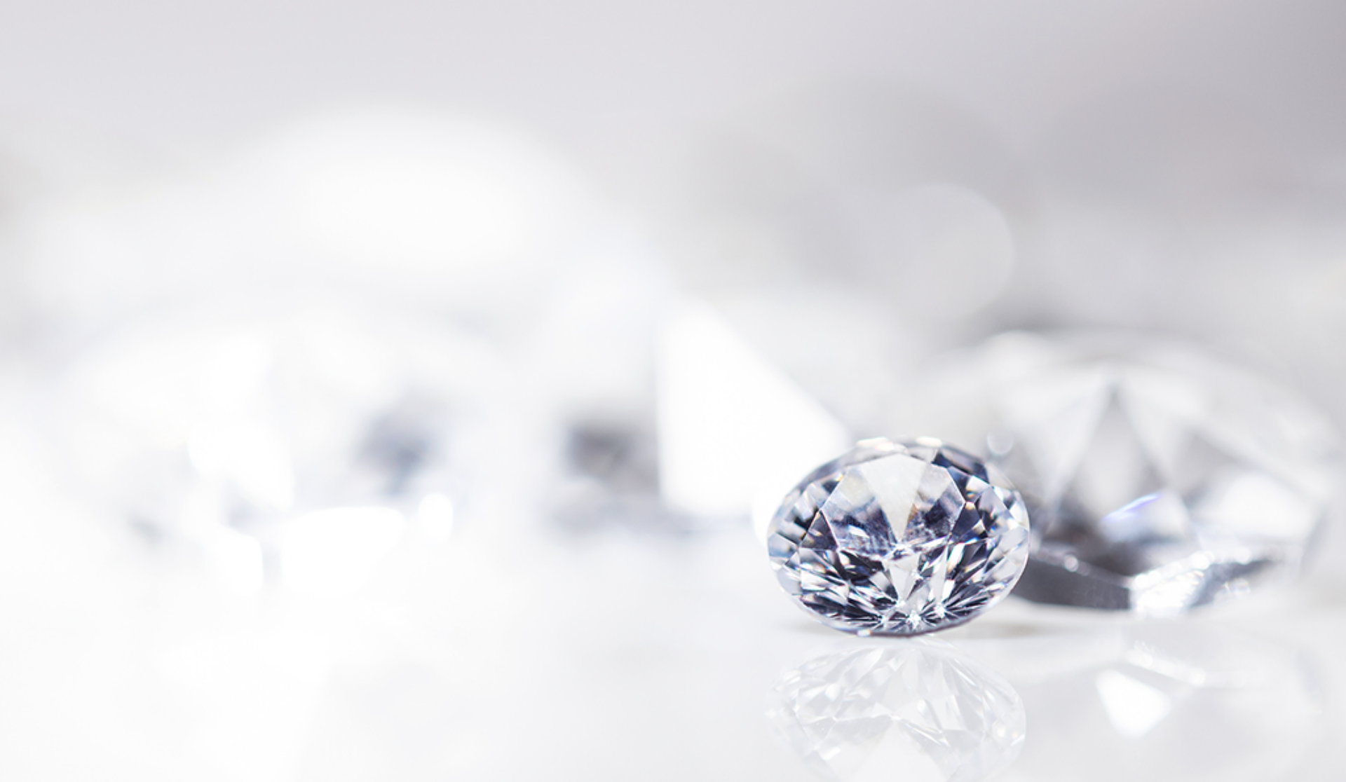 A large diamond is positioned above a group of diamonds, emphasizing their sparkling allure and exquisite design.